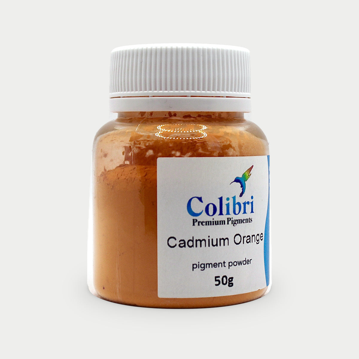 Cadmium orange pigment powder in a Colibri jar