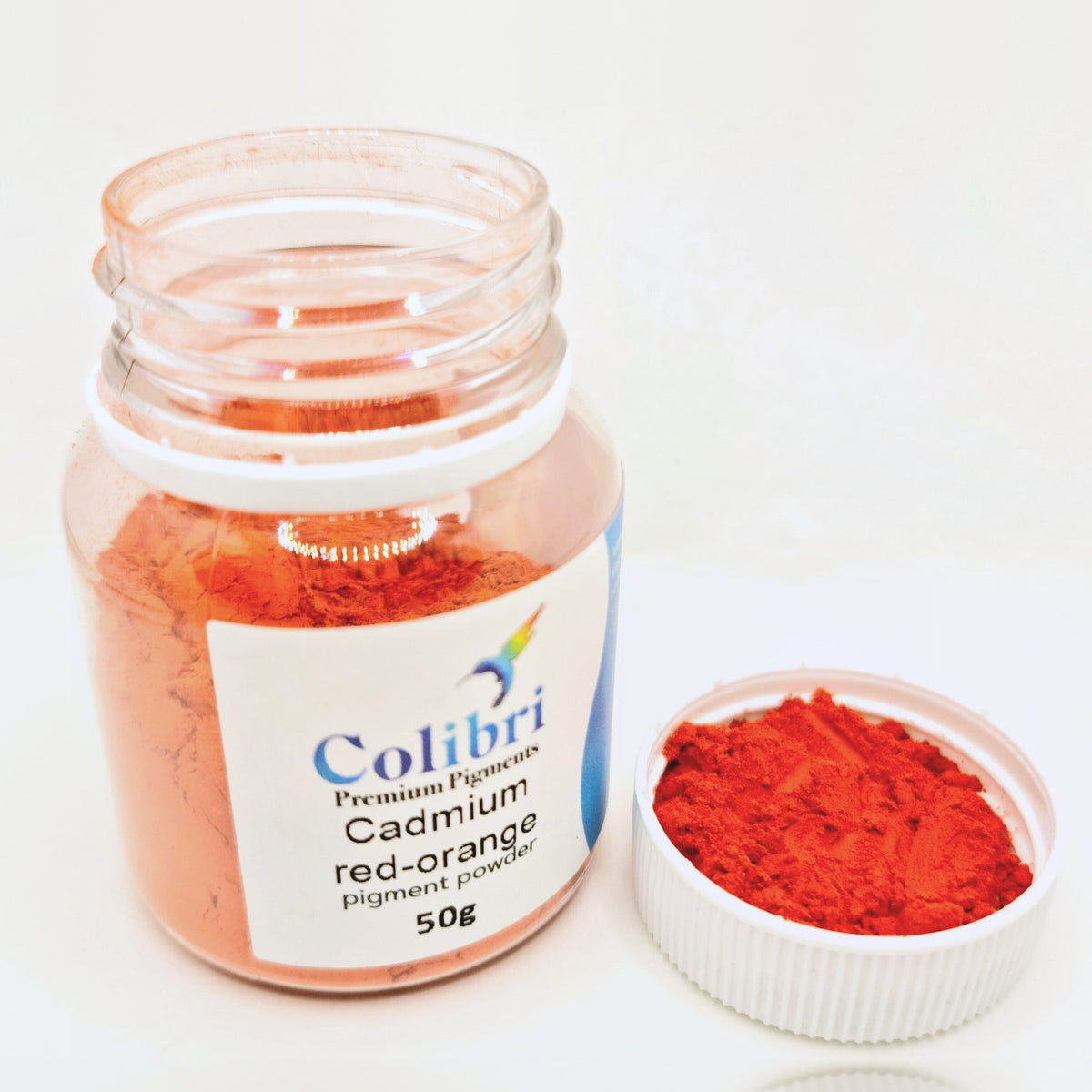 Cadmium red orange pigment powder, open jar