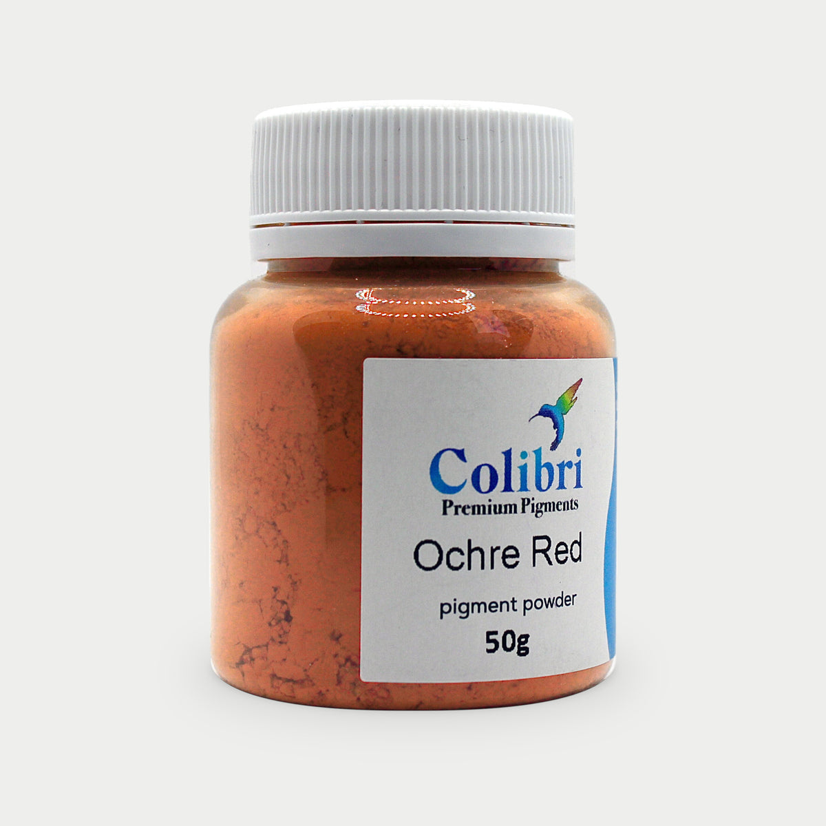 Ochre red pigment powder in a Colibri jar